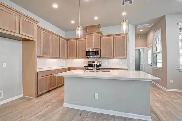 a kitchen with kitchen island granite countertop a sink stainless steel appliances and cabinets