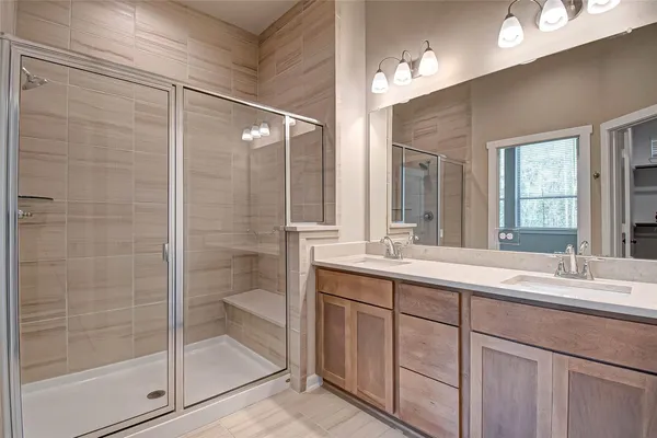 a bathroom with a shower sink and mirror