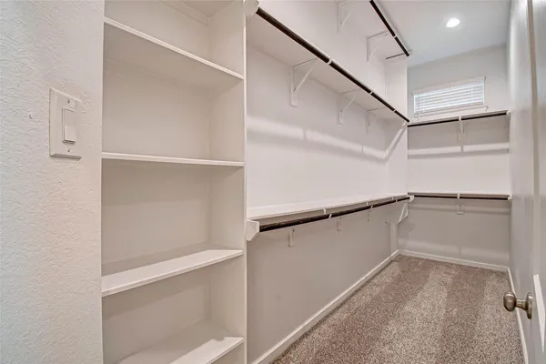 a view of walk in closet with empty racks