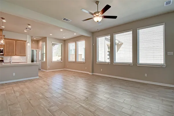 a view of an empty room with window and wooden floor