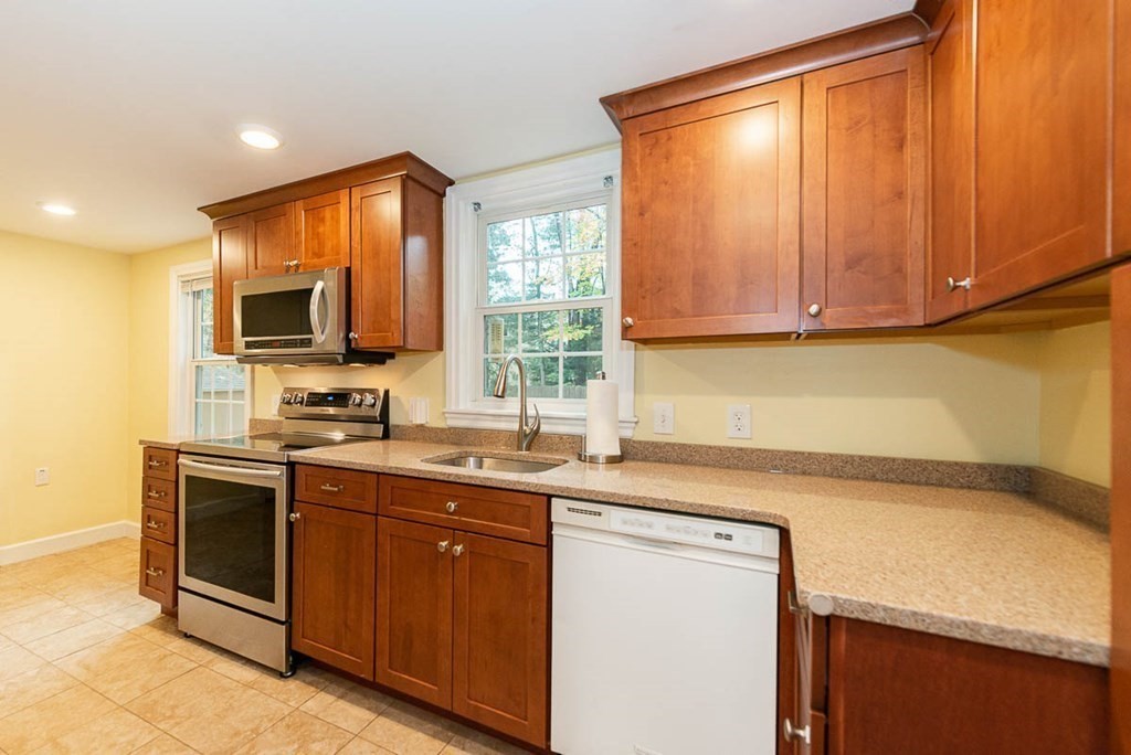 62 Spring Street Lexington, MA 02421 - Photo 15 of 32 a kitchen with stainless steel appliances granite countertop a sink stove and microwave