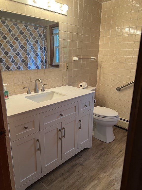 62 Spring Street Lexington, MA 02421 - Photo 24 of 32 a bathroom with a granite countertop toilet a sink and a mirror