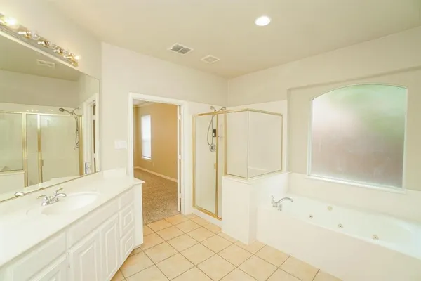 a spacious bathroom with a tub shower and sink
