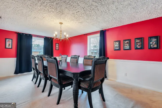 a dining room with furniture a chandelier and window