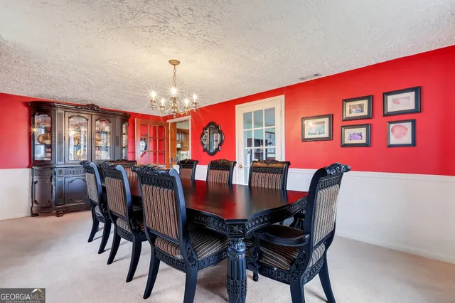 a view of a dining room with furniture and chandelier