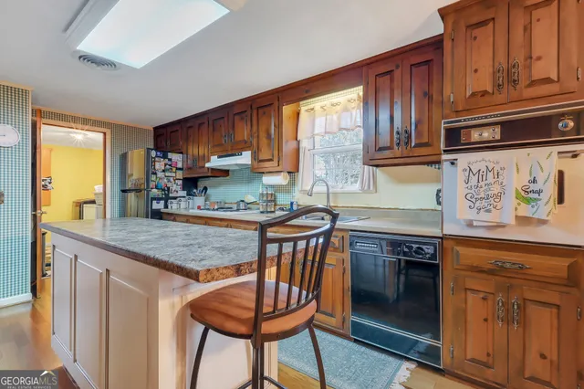 a kitchen with stainless steel appliances granite countertop a stove a sink and a refrigerator