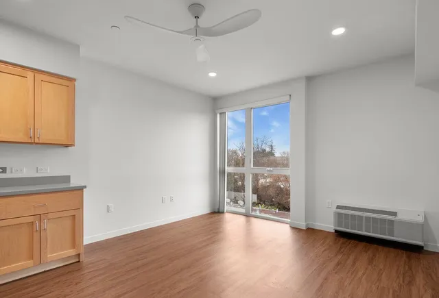 a view of a livingroom with wooden floor and a window