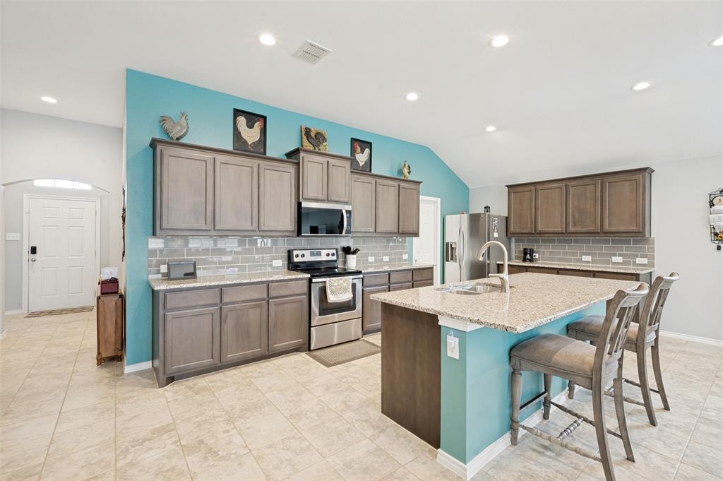 3905 Bridle Path Lane Sanger, TX 76266 - Photo 2 of 26 a kitchen with cabinets a sink and appliances