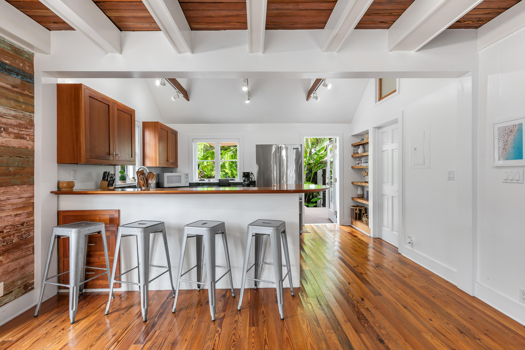 819 Elizabeth Street Key West, FL 33040 - Photo 9 of 28 a white kitchen with wooden floors and stainless steel appliances