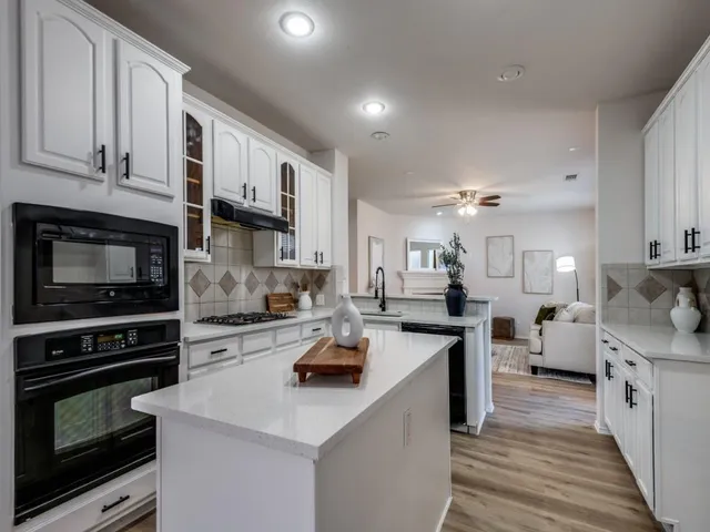 a kitchen with stainless steel appliances a stove sink microwave and cabinets