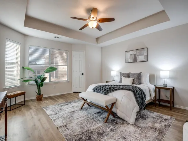 a spacious bedroom with a bed and a chandelier