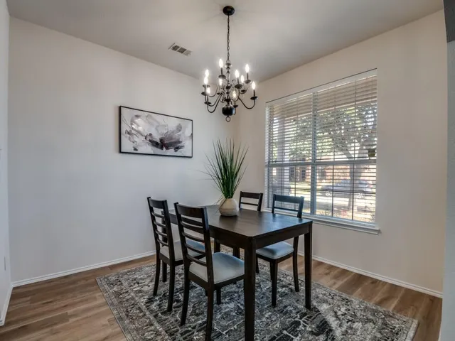 a dining room with furniture a large window and wooden floor