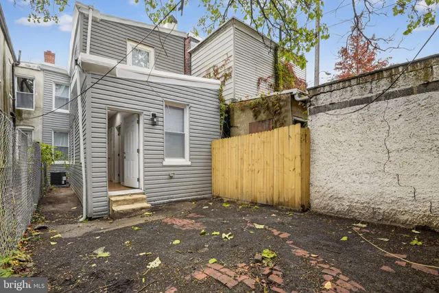 a kitchen with stainless steel appliances a refrigerator a sink and white cabinets