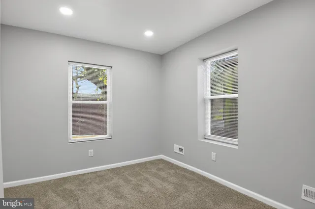 an empty room with windows and closet