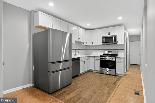 a kitchen with a refrigerator a stove top oven a sink and dishwasher