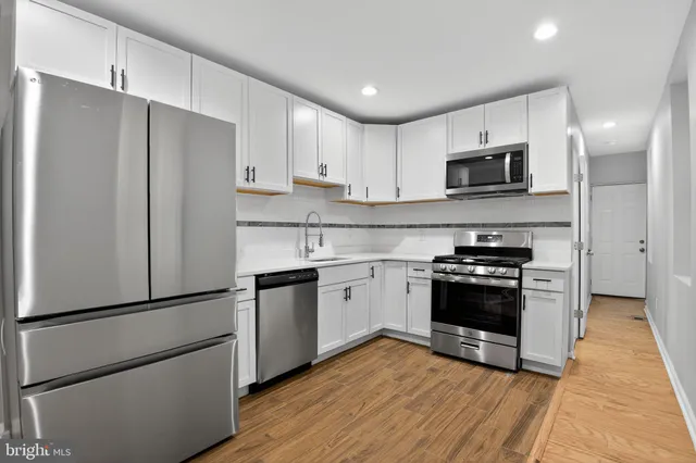 a kitchen with stainless steel appliances a refrigerator sink and microwave