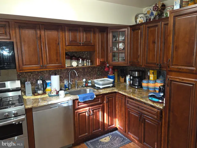 a kitchen with stainless steel appliances granite countertop a sink stove and cabinets