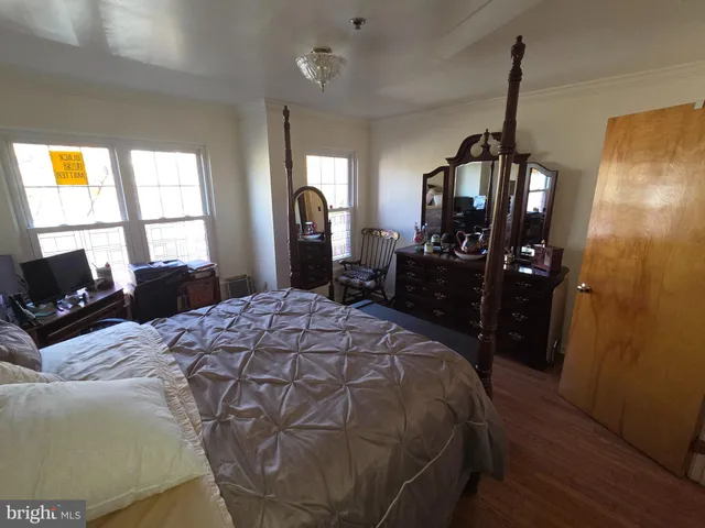 a bed room with a bed a dresser and a window