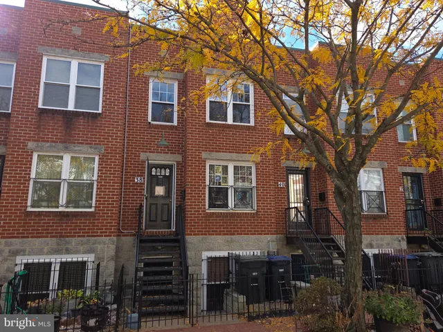 a front view of a building with glass windows and a tree