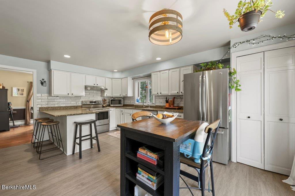 33 Eleanor Road Pittsfield, MA 01201 - Photo 19 of 45 a kitchen with a table chairs and refrigerator
