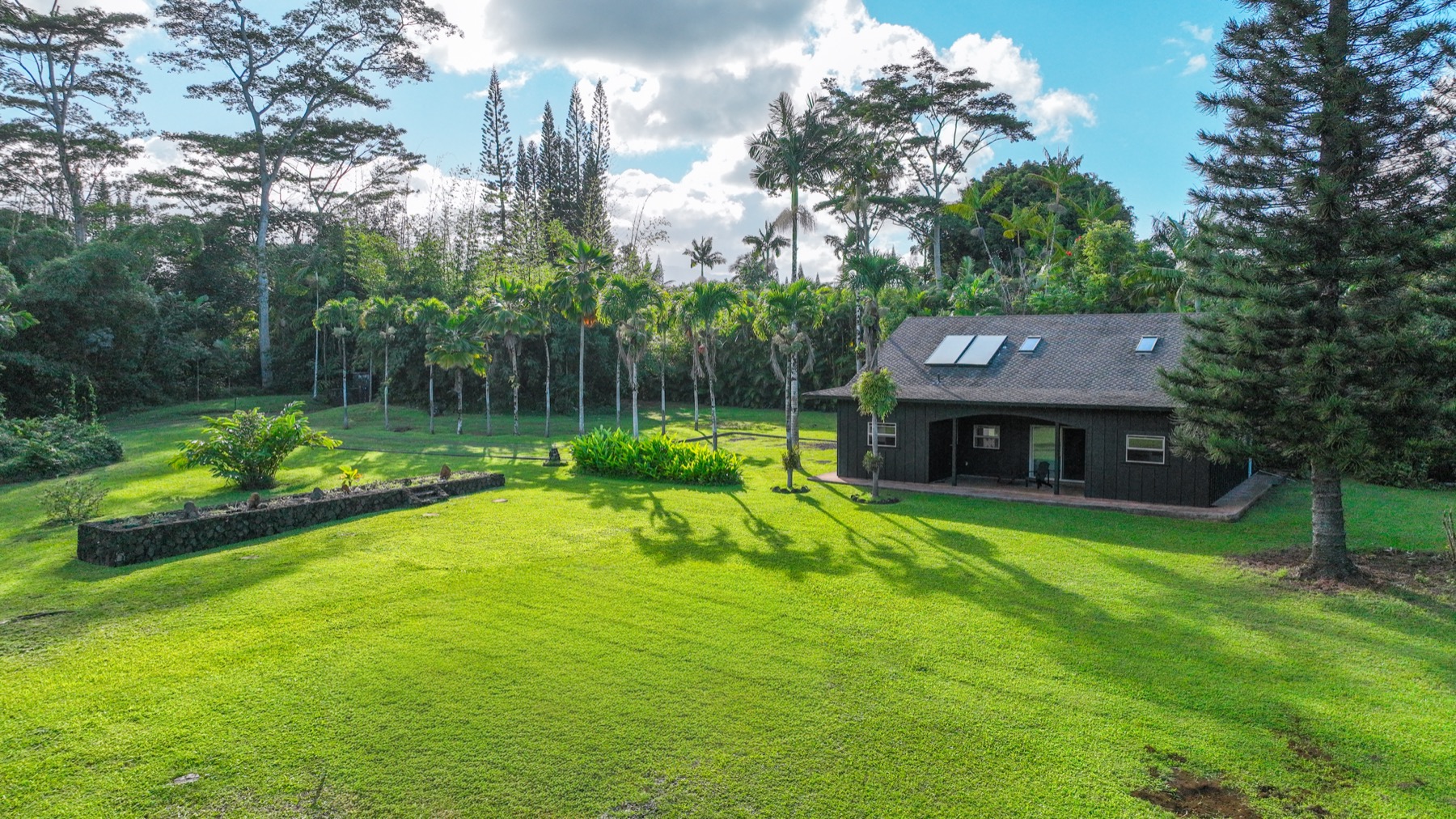 4631 Kahiliholo Road Kilauea, HI 96754 - Photo 1 of 11 a view of a big house with a big yard and large trees