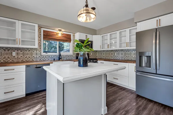a kitchen with stainless steel appliances granite countertop a sink and a refrigerator