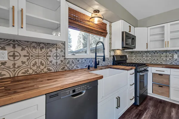 a kitchen with stainless steel appliances granite countertop a sink and a stove