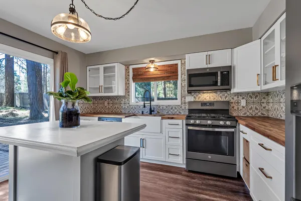 a kitchen with kitchen island granite countertop a stove sink and microwave