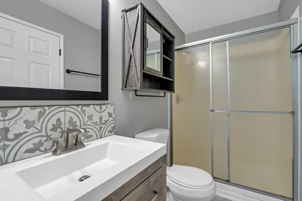 a bathroom with a sink toilet and shower