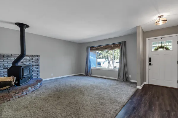 a view of empty room with a fireplace and wooden floor