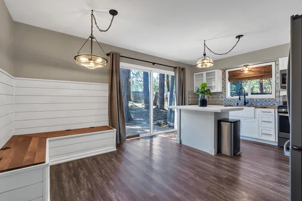 a kitchen with a refrigerator and wooden floor