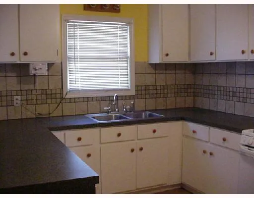 a kitchen with granite countertop white cabinets and sink