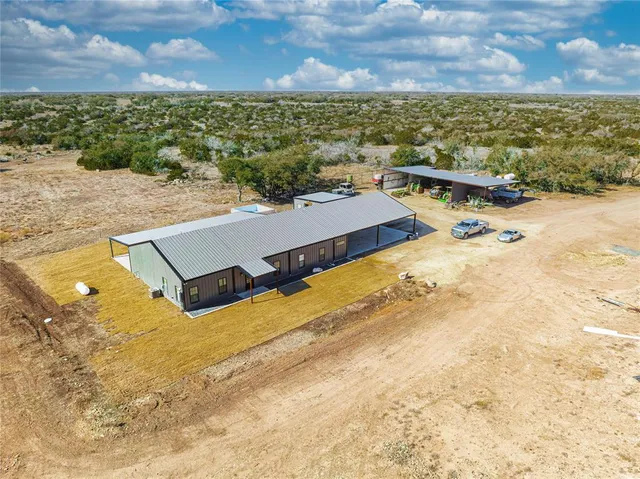 an aerial view of a house with a yard