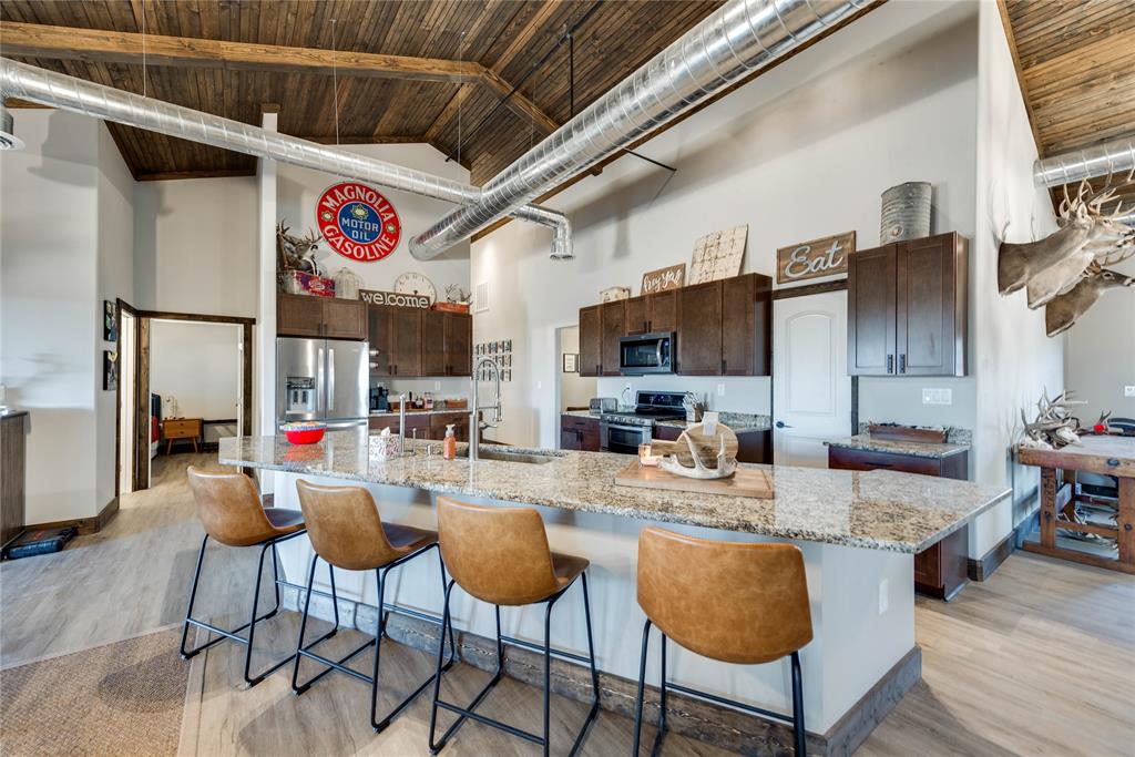 2527 Sutton County Road Ozona, TX 76943 - Photo 16 of 39 a kitchen with stainless steel appliances granite countertop a dining table chairs sink and cabinets