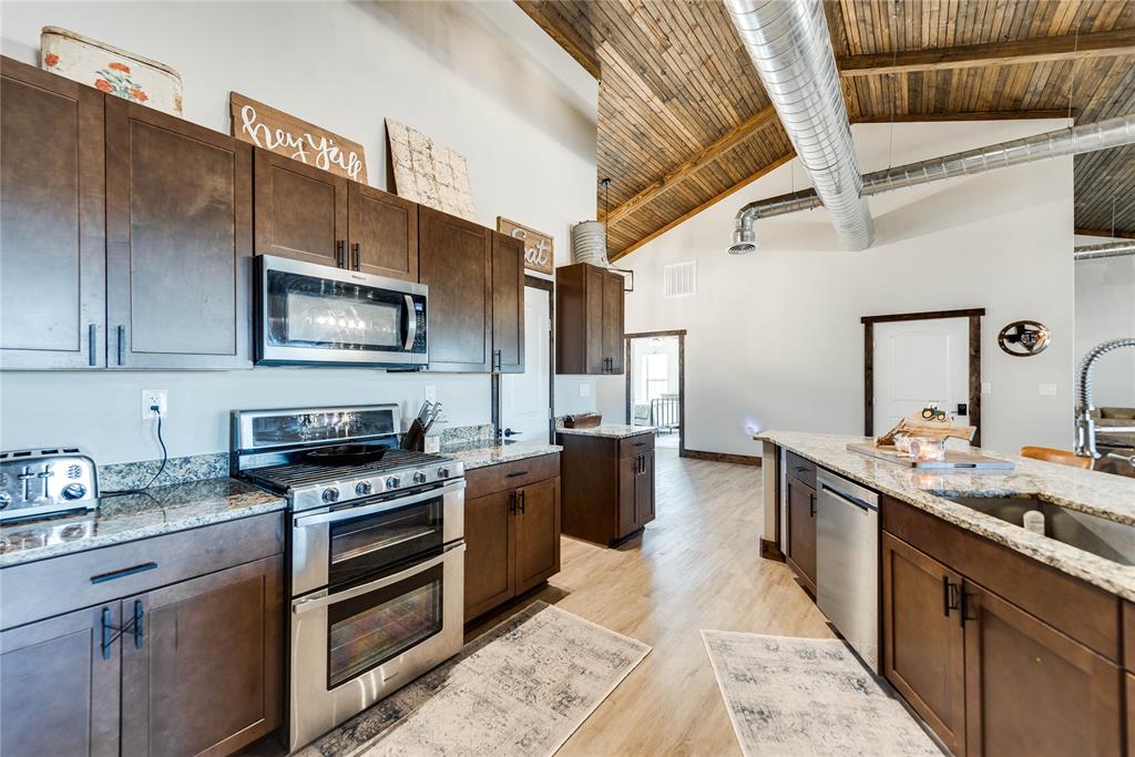 2527 Sutton County Road Ozona, TX 76943 - Photo 17 of 39 a kitchen with stainless steel appliances a stove sink microwave and cabinets