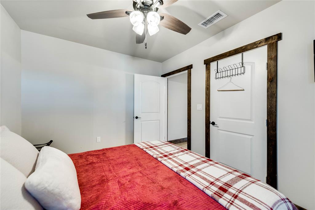 2527 Sutton County Road Ozona, TX 76943 - Photo 24 of 39 a bedroom with a bed and a chandelier