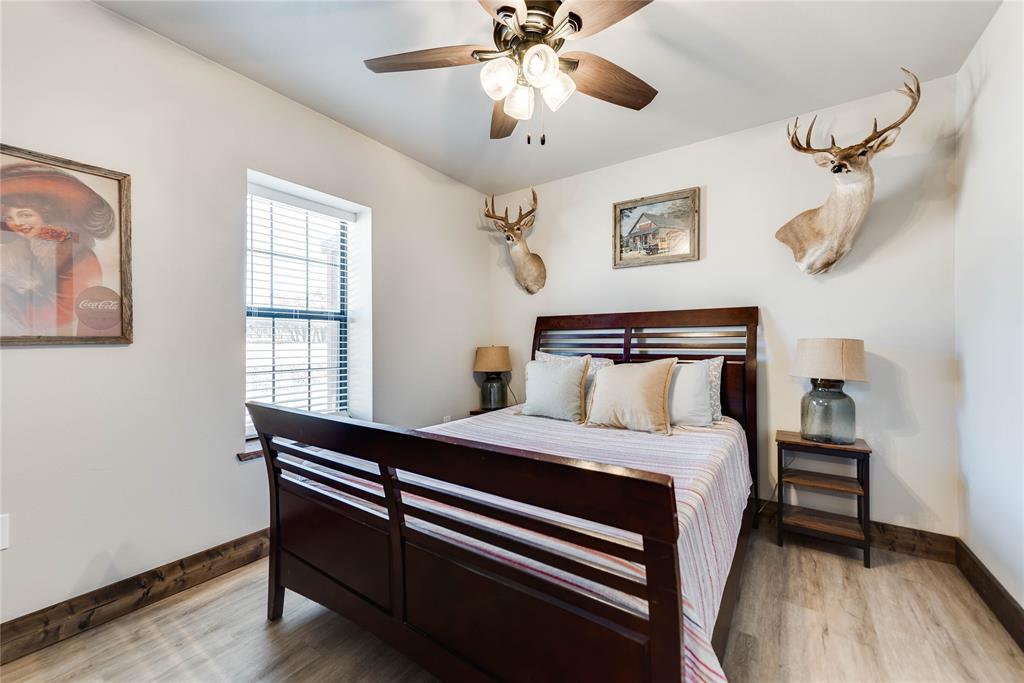 2527 Sutton County Road Ozona, TX 76943 - Photo 26 of 39 a bedroom with a bed and a chandelier