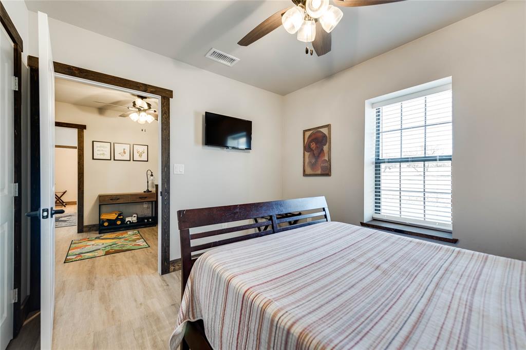 2527 Sutton County Road Ozona, TX 76943 - Photo 27 of 39 a bedroom with a large bed and a large window