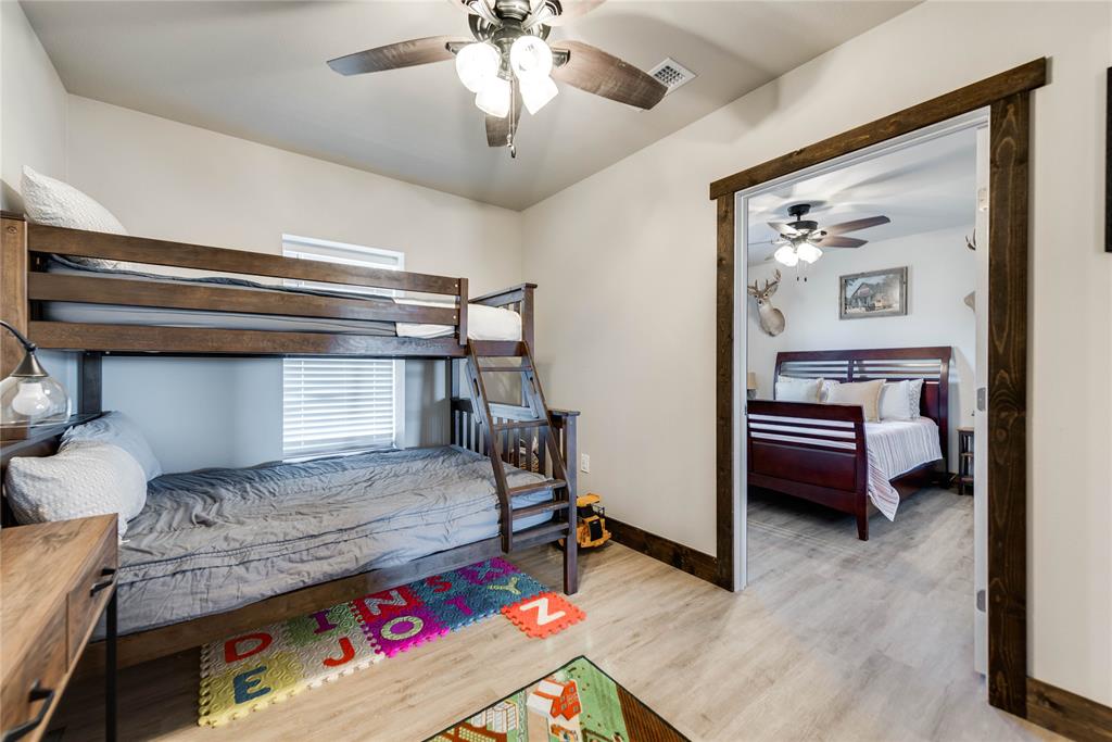 2527 Sutton County Road Ozona, TX 76943 - Photo 29 of 39 a bedroom with a bed and a chandelier