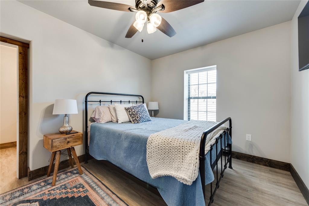 2527 Sutton County Road Ozona, TX 76943 - Photo 30 of 39 a bedroom with a bed and wooden floor