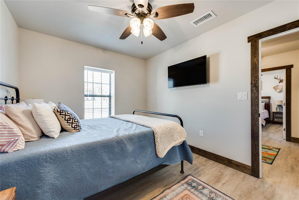 2527 Sutton County Road Ozona, TX 76943 - Photo 31 of 39 a bedroom with a bed and a flat screen tv