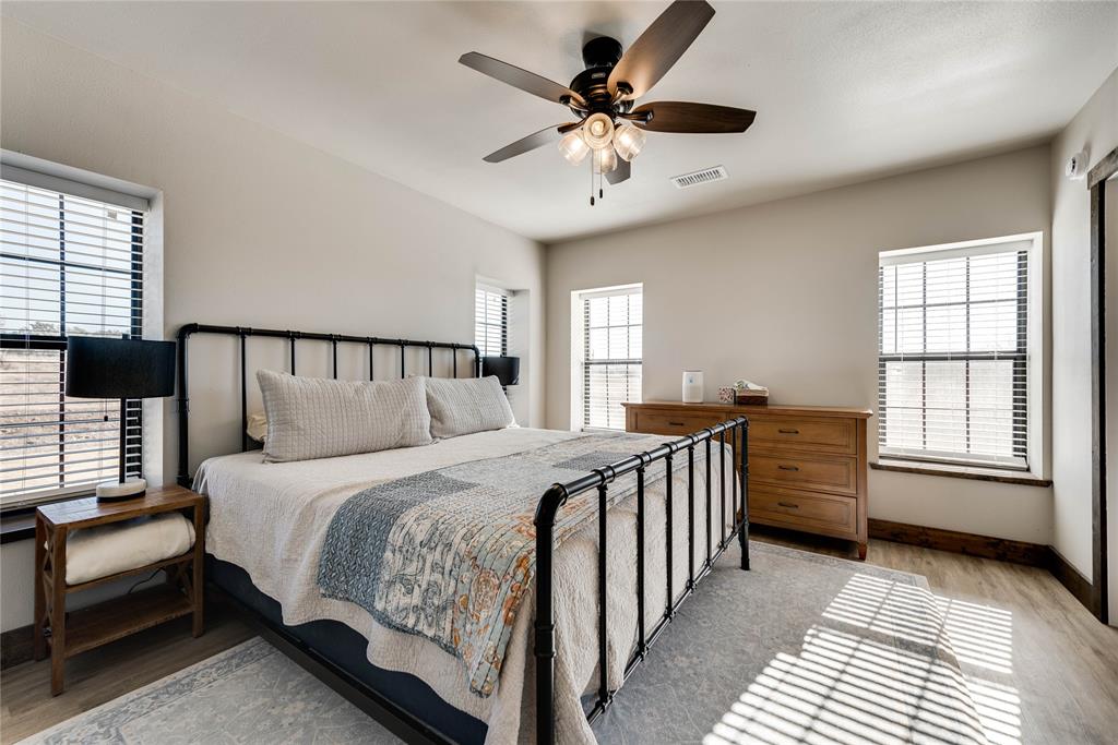 2527 Sutton County Road Ozona, TX 76943 - Photo 35 of 39 a bedroom with a bed and a chandelier