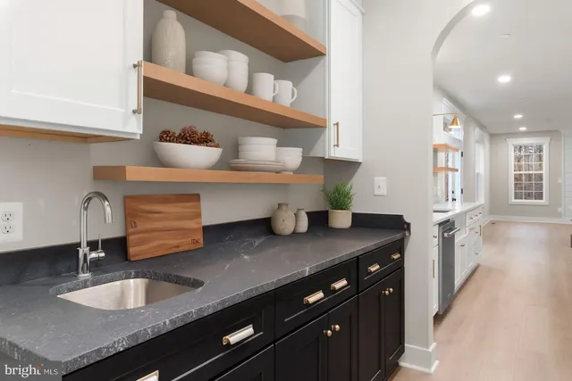 a kitchen with granite countertop a sink a stove and cabinets