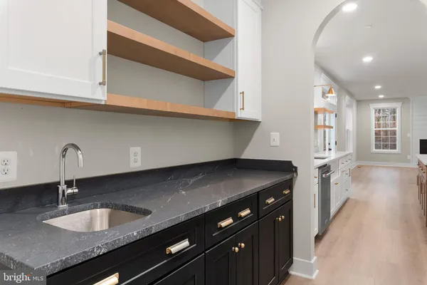 a kitchen with granite countertop a sink and a stove