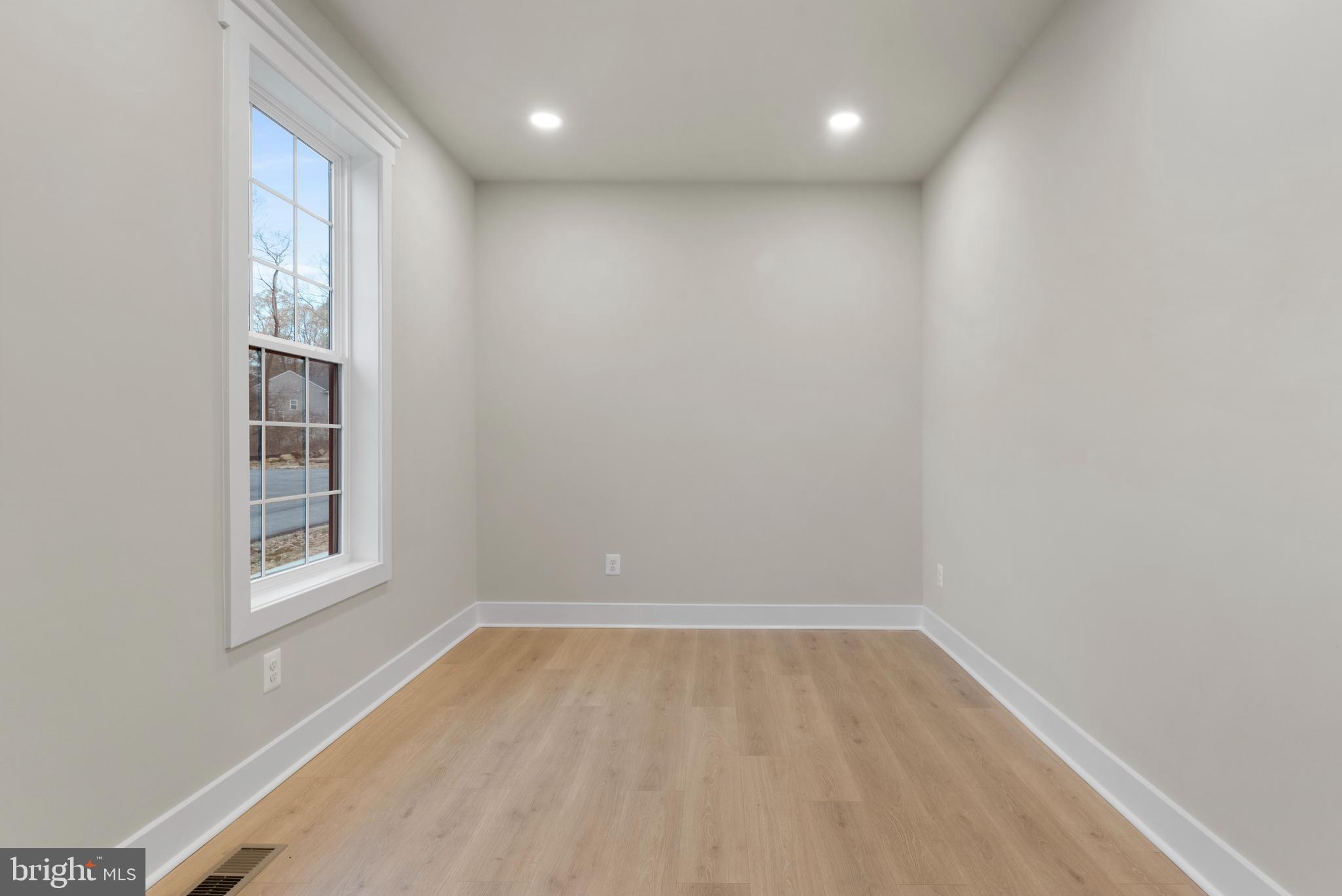 17 Vinter Lane Pasadena, MD 21122 - Photo 16 of 40 a view of empty room with wooden floor and fan