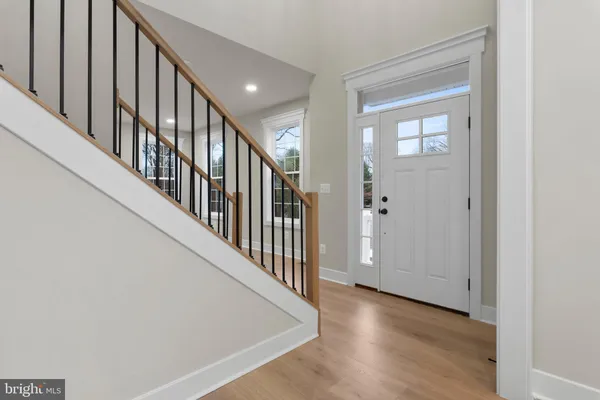 a view of a hallway with wooden floor and staircase