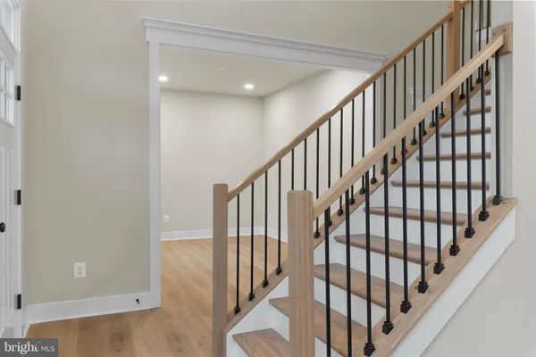 a view of staircase with wooden floor and white walls