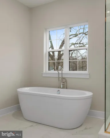 a white bath tub sitting in a bathroom next to a window