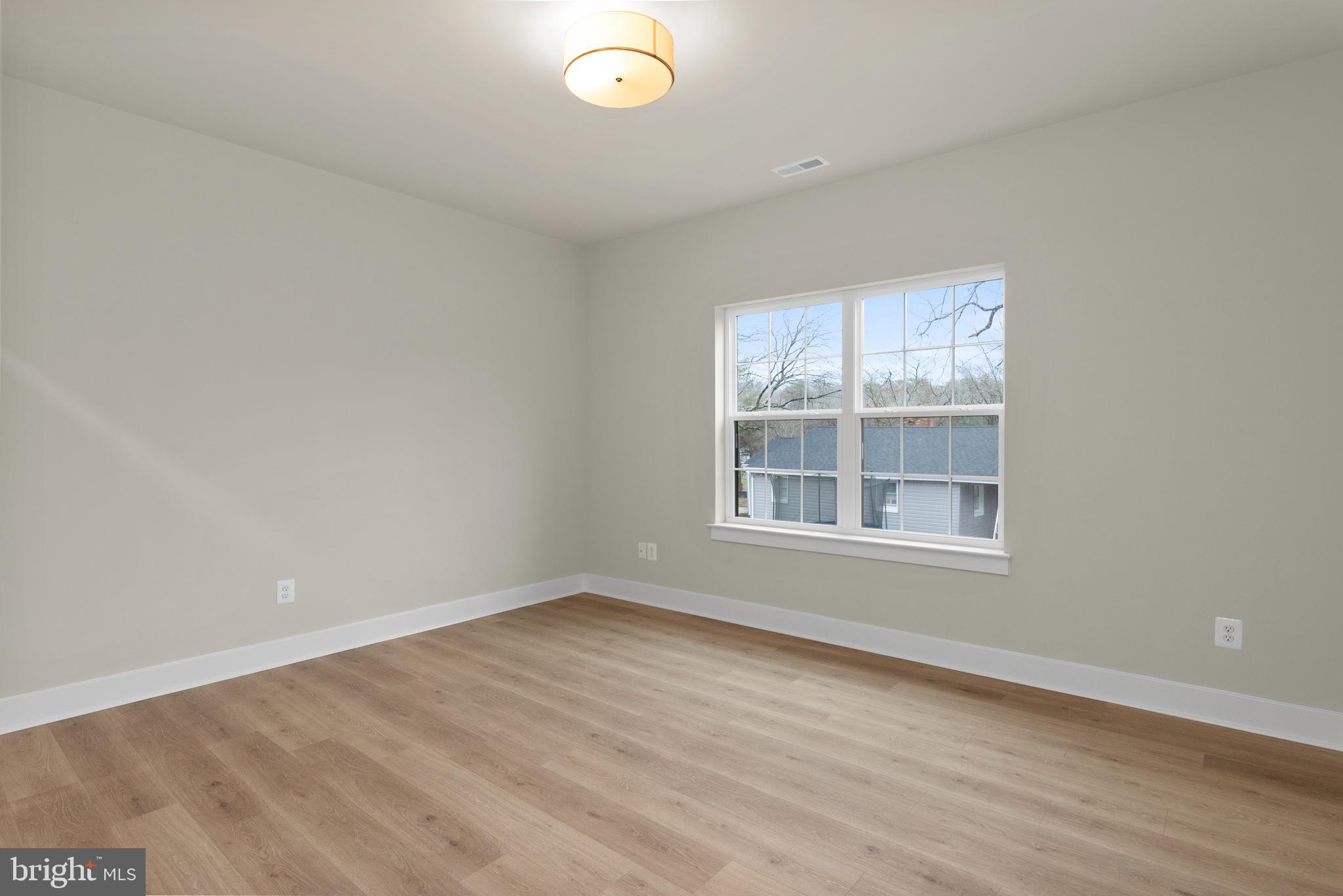 17 Vinter Lane Pasadena, MD 21122 - Photo 29 of 40 an empty room with wooden floor and windows
