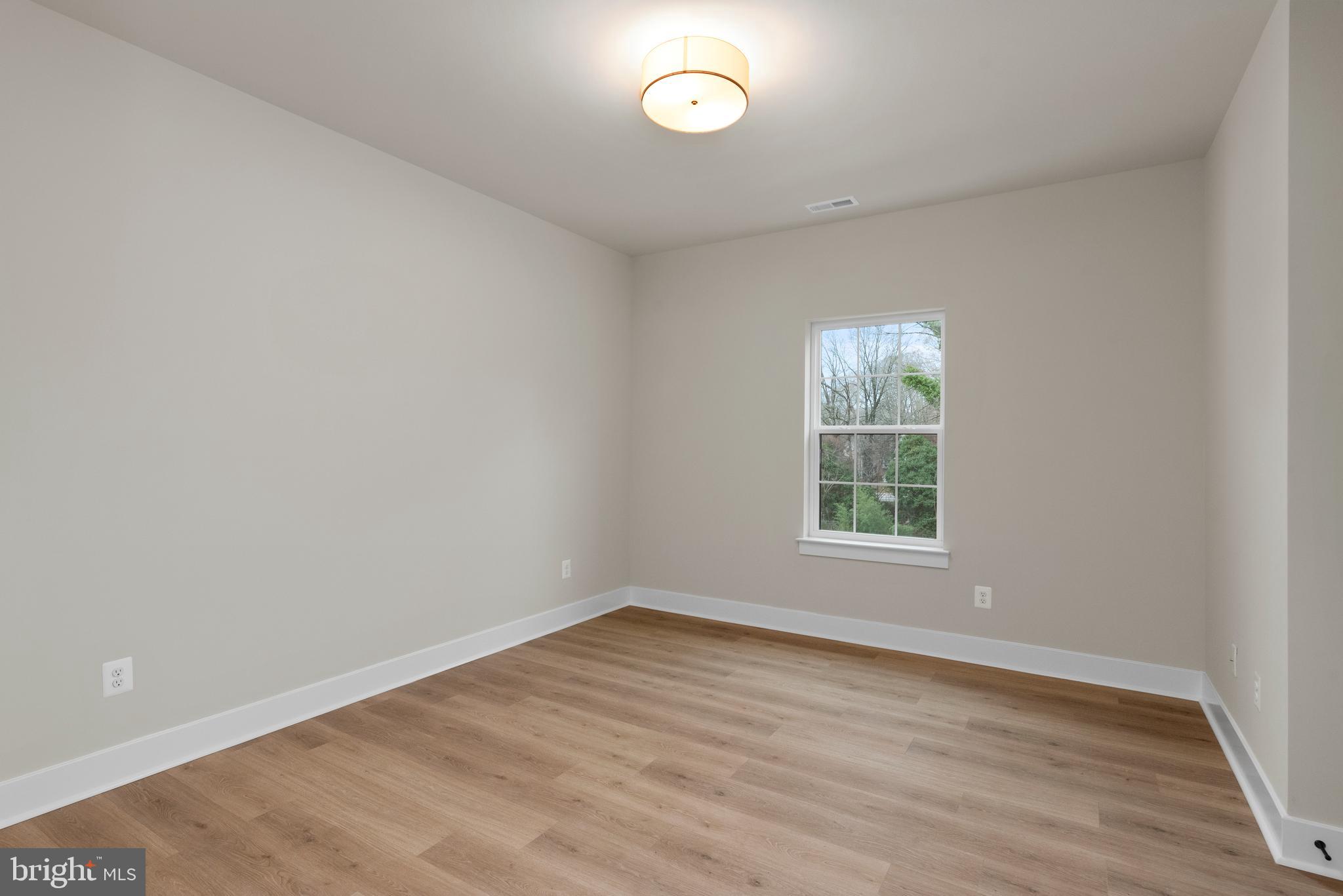 17 Vinter Lane Pasadena, MD 21122 - Photo 34 of 40 an empty room with wooden floor and a window